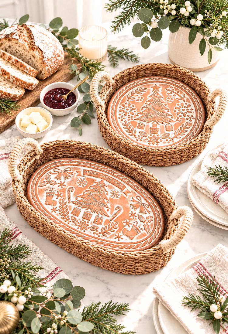 Oval and round terracotta Christmas bread warmers in seagrass baskets on a holiday table