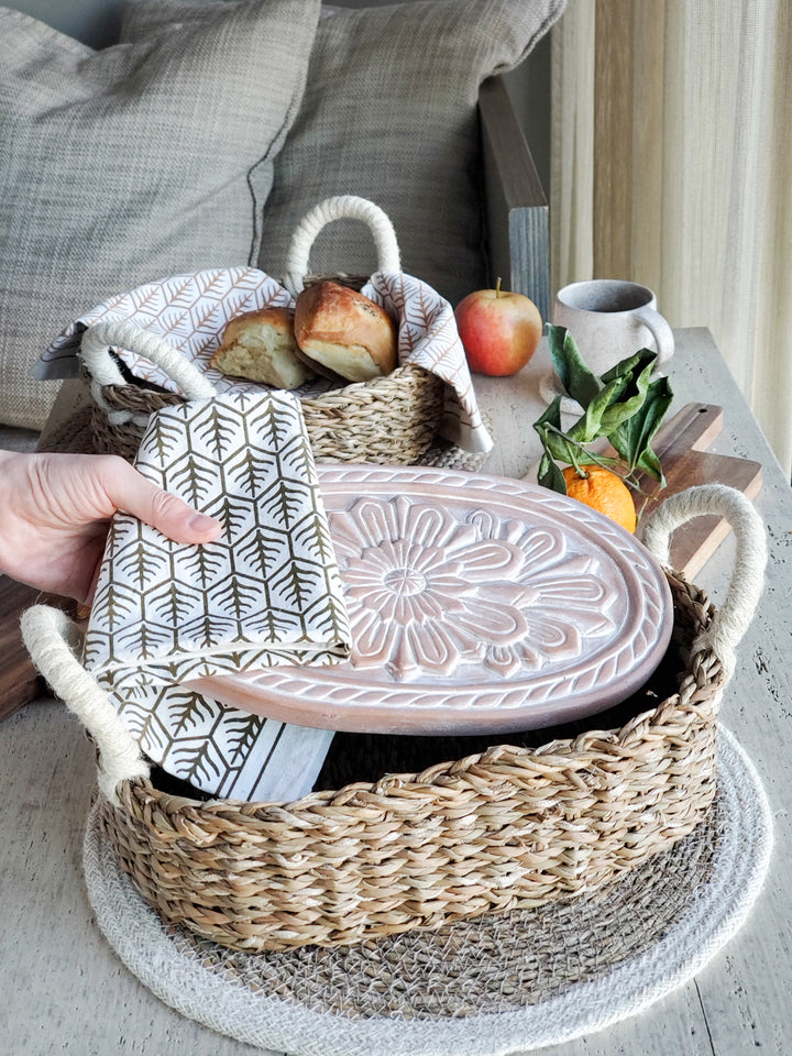 Terracotta plate engraved with a flower design is served with a hand screen printed tea towel.
