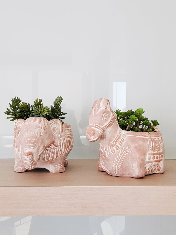  Playful pottery in the shape of animals are molded into fun shapes that can be filled with lots of colorful flowers or green plant